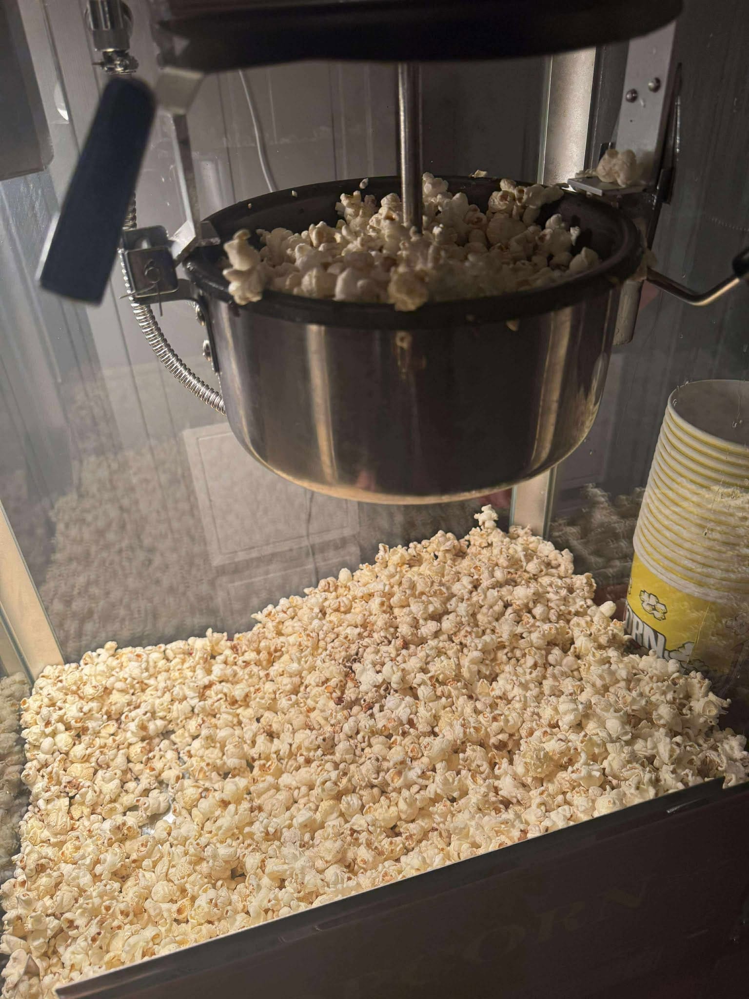Popcornbeger med rød og hvit stripe ved popcornmaskinen