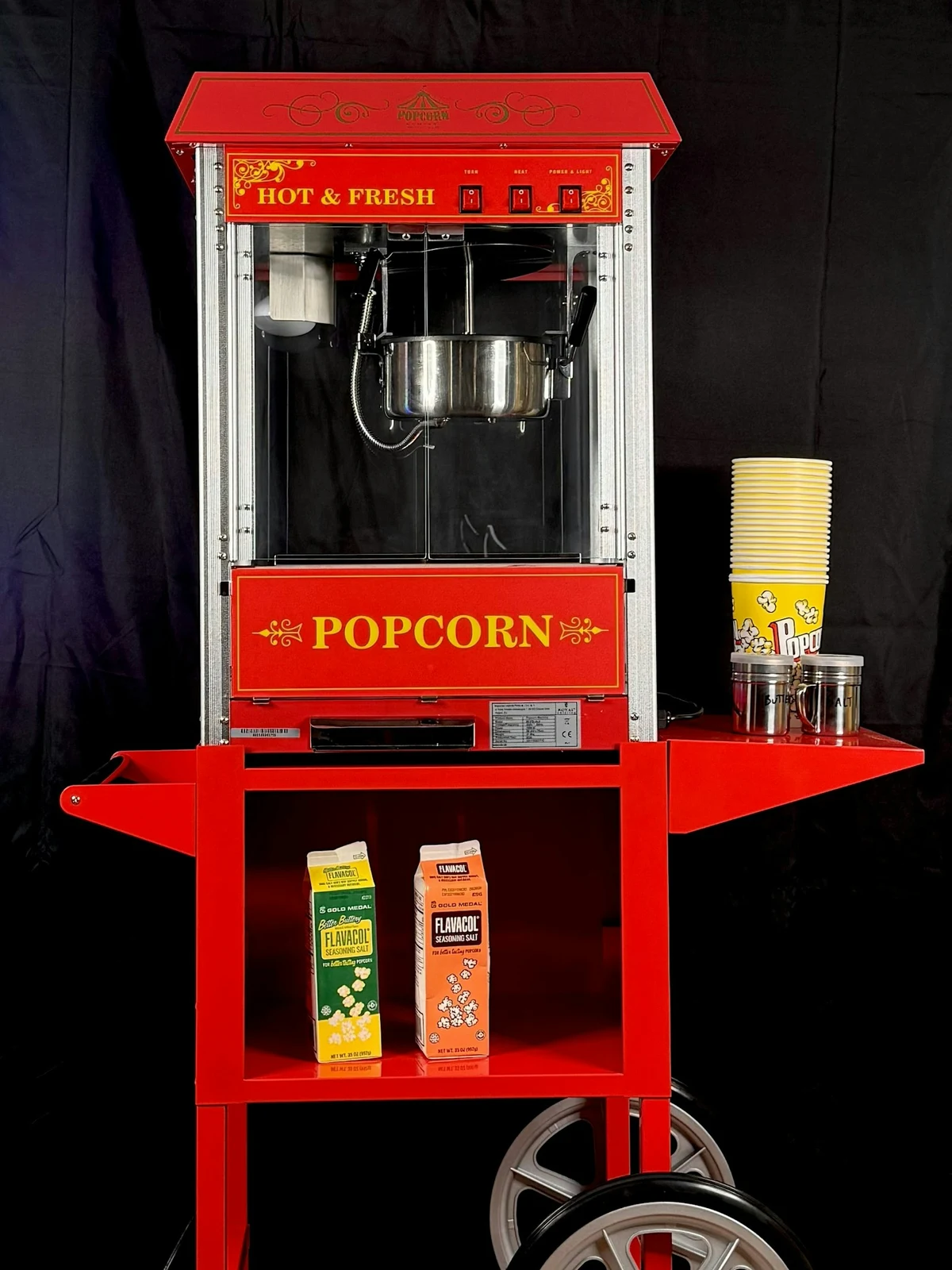 Retro popcornmaskin på vogn med beger og salt