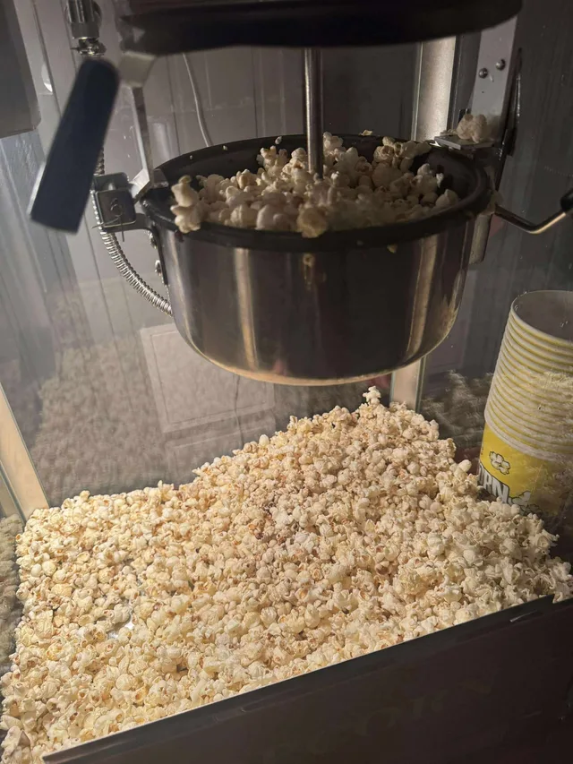 Popcornbeger med rød og hvit stripe ved popcornmaskinen