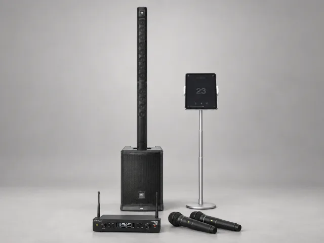 Karaokepakke med JBL PRX ONE, to trådløse mikrofoner, mottaker og iPad på grå studiobakgrunn